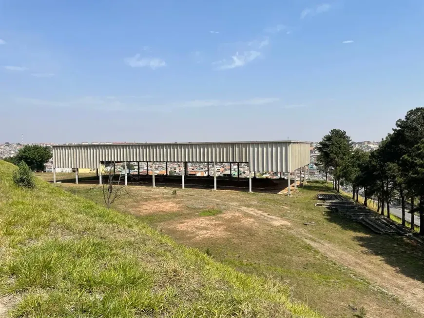 galpão industrial moderno com estrutura de concreto, pé direito alto, iluminação natural, ambiente limpo e bem organizado