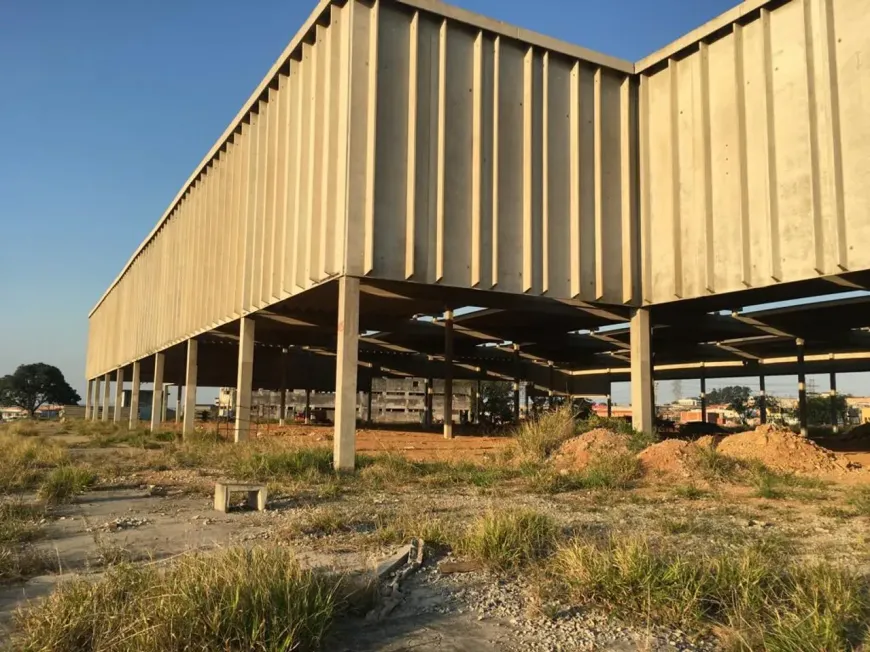 galpão industrial com piso de concreto polido, estrutura metálica, grandes portas de acesso, ambiente espaçoso e bem iluminado